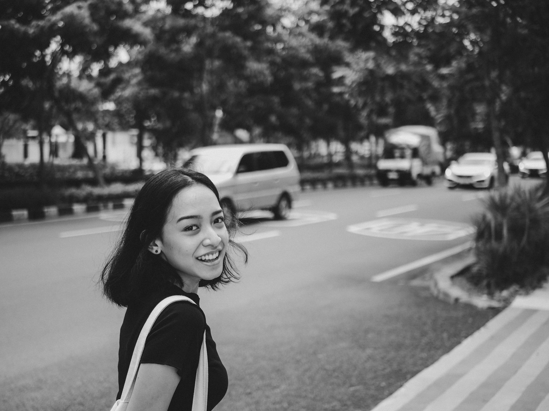 A woman walking down a street next to a cross walk